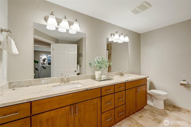 12724 NE 144th St Unit E-104, Kirkland, WA 98034 - full bathroom with double vanity, toilet, stone finish flooring, and baseboards