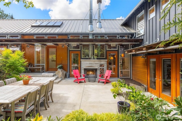10611 NE 155th Pl, Bothell, WA 98011 - view of patio with french doors, outdoor dining space, and an outdoor stone fireplace