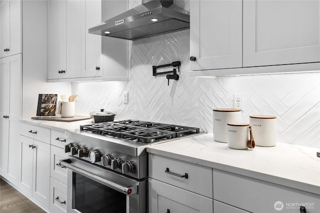 14636 203rd Ave E Unit 19, Bonney Lake, WA 98391 - kitchen with stainless steel stove, wall chimney range hood, tasteful backsplash, and white cabinets