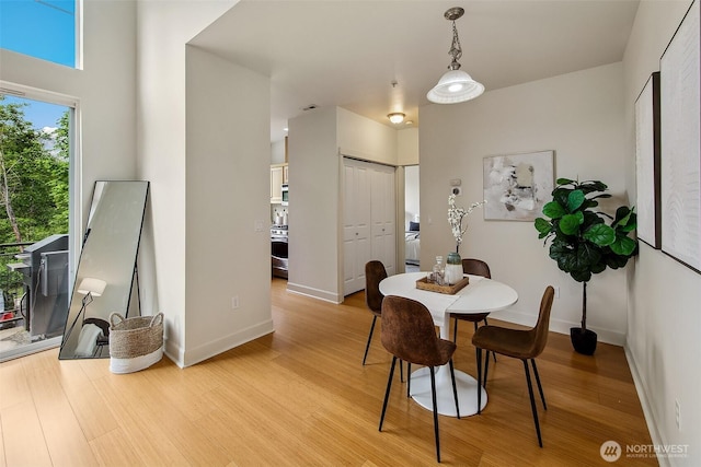 dining area featuring light wood-style flooring and baseboards