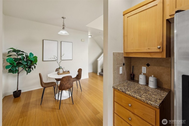 dining area featuring light wood-style floors and baseboards