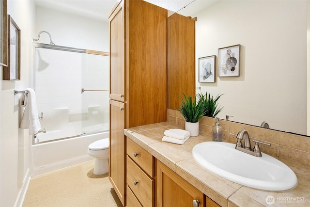 full bath with toilet, vanity, and bath / shower combo with glass door