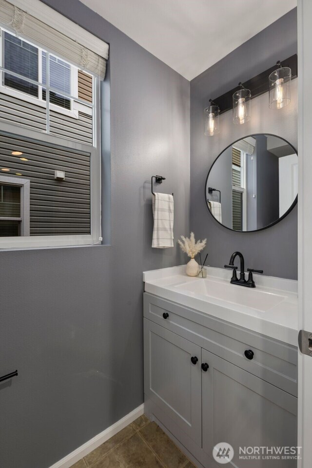 bathroom with baseboards, vanity, and tile patterned floors
