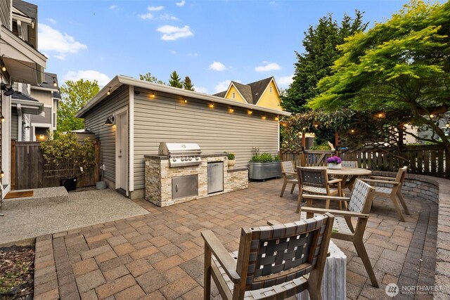 view of patio / terrace featuring an outdoor kitchen, area for grilling, fence, and outdoor dining area