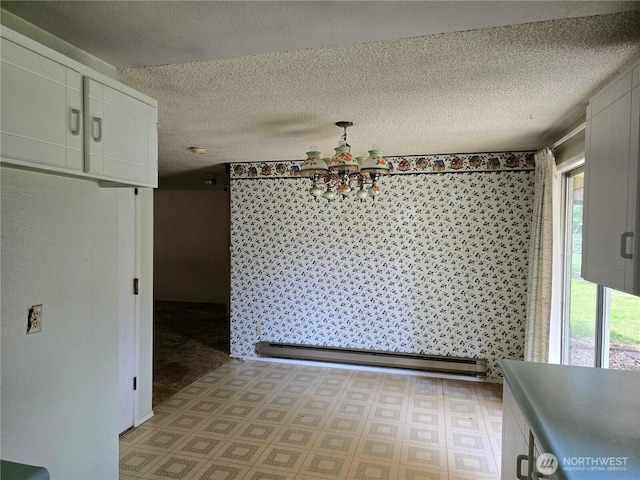 unfurnished dining area featuring a baseboard radiator, a chandelier, a textured ceiling, and light floors
