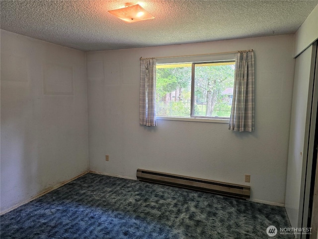 spare room with a baseboard radiator, carpet flooring, and a textured ceiling