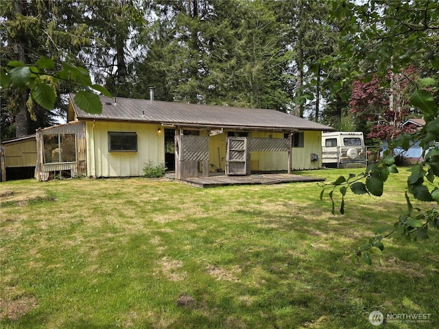 view of front of property featuring board and batten siding, a front yard, and metal roof