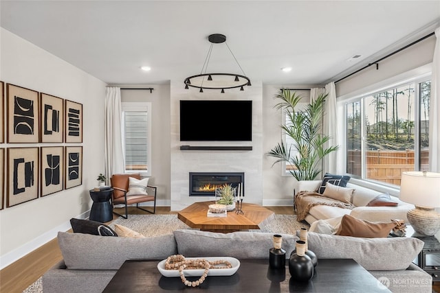 20304 154th St E Unit 15, Bonney Lake, WA 98391 - living area with a glass covered fireplace, wood finished floors, baseboards, and recessed lighting