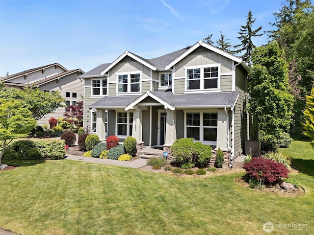 craftsman house with board and batten siding and a front yard