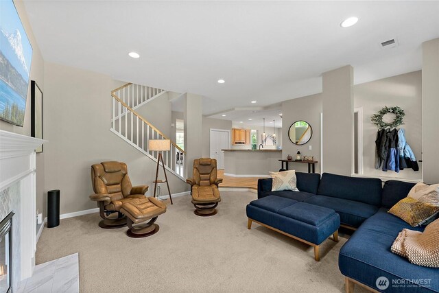 carpeted living area with a high end fireplace, stairway, recessed lighting, and baseboards