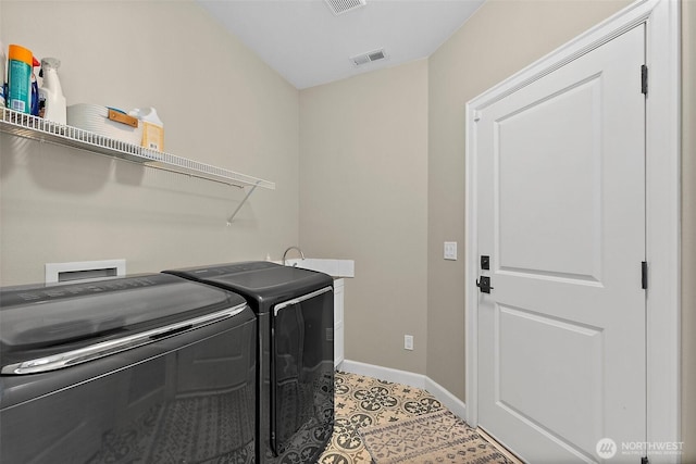 clothes washing area featuring washer and dryer and baseboards