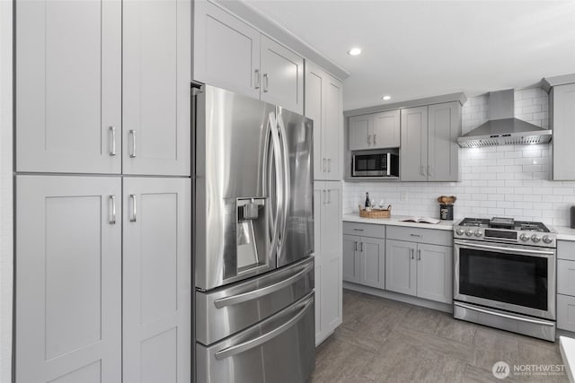 8155 28th Ave SW, Seattle, WA 98126 - kitchen with appliances with stainless steel finishes, wall chimney exhaust hood, light countertops, gray cabinetry, and recessed lighting