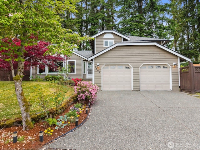 view of front of house featuring an attached garage, concrete driveway, and roof with shingles