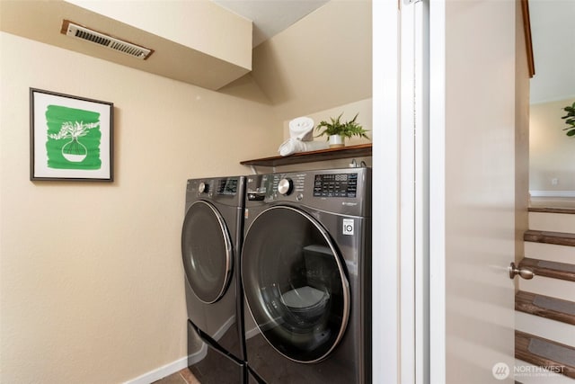 laundry area with separate washer and dryer and baseboards