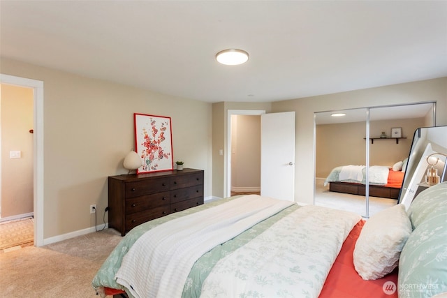 carpeted bedroom featuring a closet and baseboards