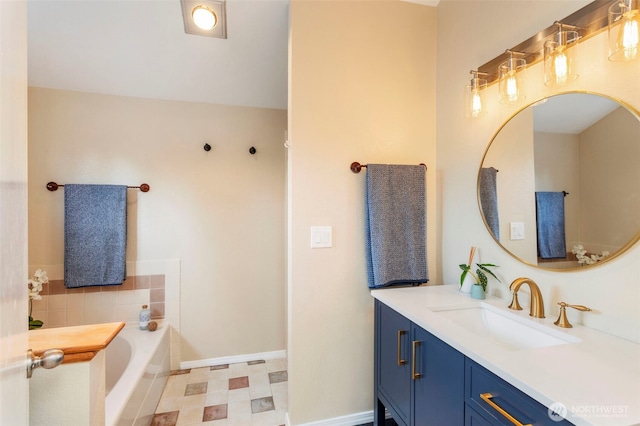 full bath with a bath, baseboards, vanity, and tile patterned floors