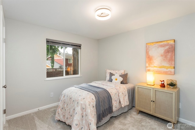 bedroom with light colored carpet and baseboards