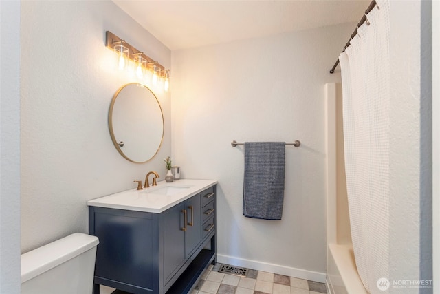 bathroom with toilet, vanity, a shower with curtain, and baseboards