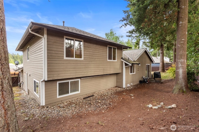 rear view of property featuring roof with shingles