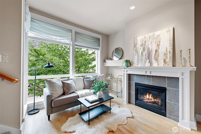 708 Market St Unit 409, Tacoma, WA 98402 - living area featuring wood finished floors, a tiled fireplace, baseboards, and recessed lighting