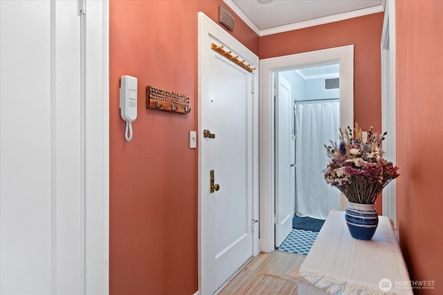 hall featuring crown molding, light wood-type flooring, and baseboards