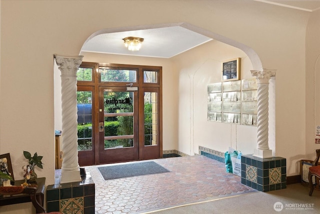 foyer featuring arched walkways and decorative columns