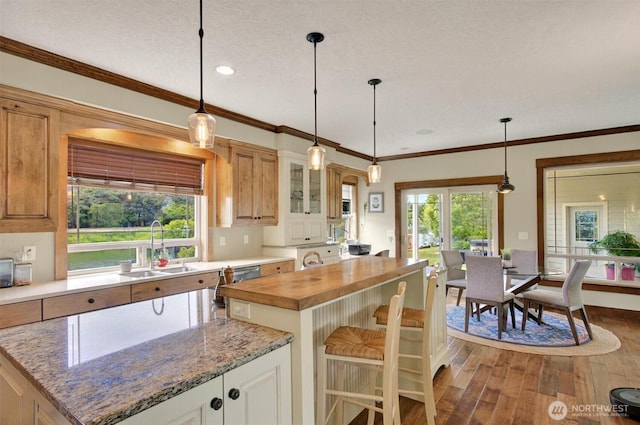 45 N Welcome Slough Rd, Cathlamet, WA 98612 - kitchen with a sink, dark wood-style floors, butcher block counters, hanging light fixtures, and glass insert cabinets