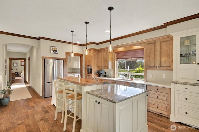 45 N Welcome Slough Rd, Cathlamet, WA 98612 - kitchen with stainless steel appliances, arched walkways, a sink, a center island, and wood finished floors