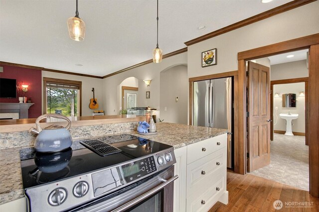 45 N Welcome Slough Rd, Cathlamet, WA 98612 - kitchen with appliances with stainless steel finishes, arched walkways, ornamental molding, white cabinets, and light wood finished floors