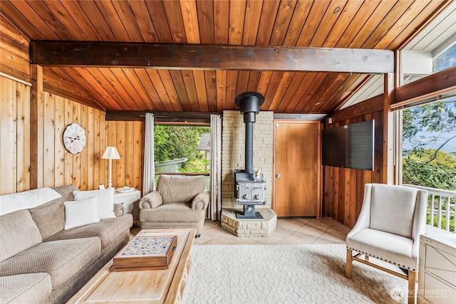 8310 E State Route 106, Union, WA 98592 - living area featuring healthy amount of natural light, a wood stove, wooden walls, wood ceiling, and light tile patterned floors