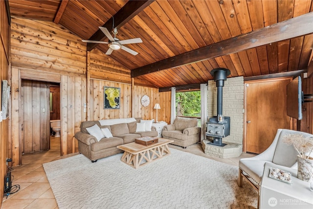 8310 E State Route 106, Union, WA 98592 - living room with a wood stove, wood walls, wood ceiling, tile patterned floors, and a ceiling fan