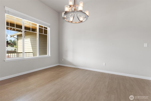 1803 135th Street Ct S, Tacoma, WA 98444 - spare room with a chandelier, wood finished floors, and baseboards