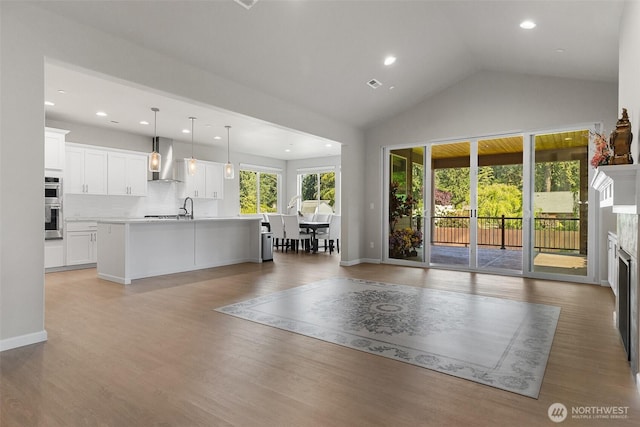 1803 135th Street Ct S, Tacoma, WA 98444 - living area featuring light wood-style flooring, a fireplace, recessed lighting, high vaulted ceiling, and baseboards