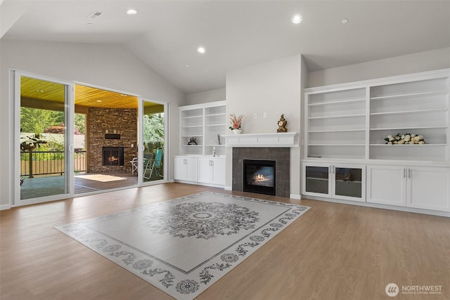 1803 135th Street Ct S, Tacoma, WA 98444 - unfurnished living room featuring a tile fireplace, wood finished floors, vaulted ceiling, built in features, and recessed lighting