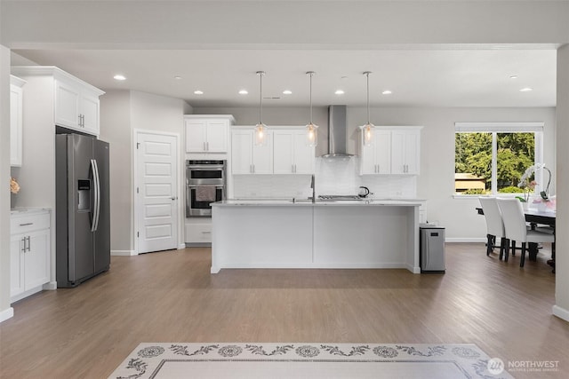 1803 135th Street Ct S, Tacoma, WA 98444 - kitchen with stainless steel appliances, wall chimney range hood, backsplash, light wood-style floors, and light countertops