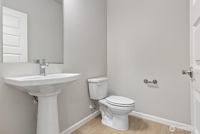 1803 135th Street Ct S, Tacoma, WA 98444 - half bathroom featuring baseboards, toilet, and wood finished floors