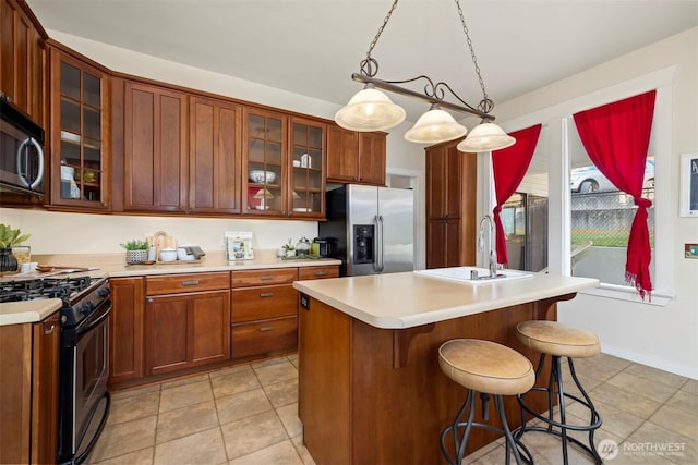 1005 15th St, Bellingham, WA 98225 - kitchen with stainless steel appliances, light countertops, a breakfast bar area, hanging light fixtures, and glass insert cabinets