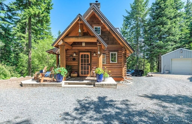 20 Skull Springs Rd, Cle Elum, WA 98922 - log cabin featuring an outdoor structure, a chimney, a garage, gravel driveway, and log exterior