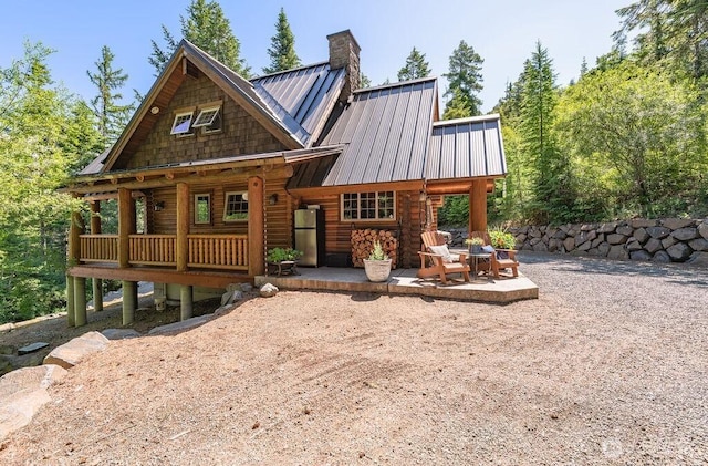 20 Skull Springs Rd, Cle Elum, WA 98922 - back of house with a chimney, a patio area, log siding, and metal roof
