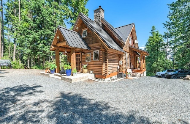 20 Skull Springs Rd, Cle Elum, WA 98922 - view of front of house featuring a standing seam roof, log siding, metal roof, a chimney, and driveway