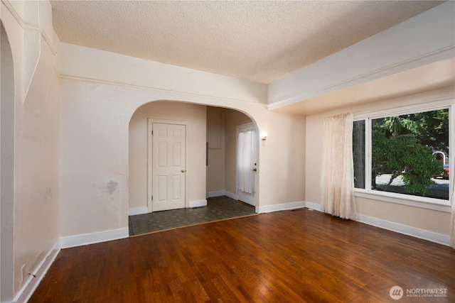 766 120th St S Unit A & B, Tacoma, WA 98444 - spare room with arched walkways, wood finished floors, a textured ceiling, and baseboards