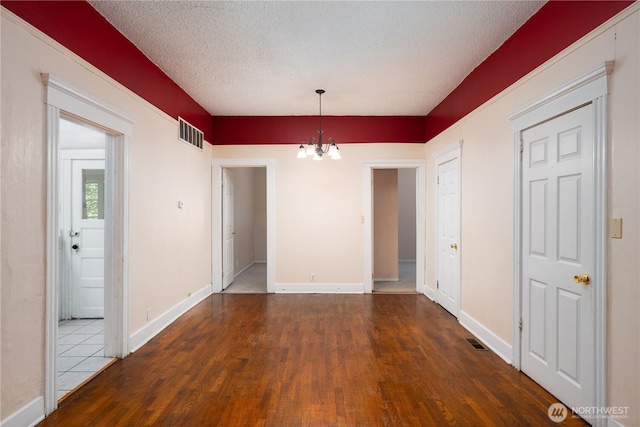 766 120th St S Unit A & B, Tacoma, WA 98444 - unfurnished dining area with a chandelier, wood finished floors, baseboards, and a textured ceiling
