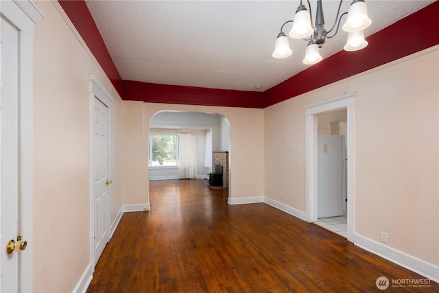 766 120th St S Unit A & B, Tacoma, WA 98444 - unfurnished dining area with arched walkways, a chandelier, wood finished floors, and baseboards