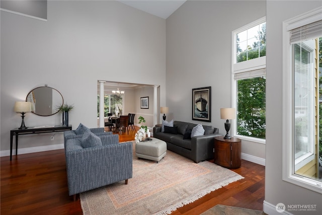9702 S 230th Pl, Kent, WA 98031 - living room featuring a high ceiling, a chandelier, wood finished floors, baseboards, and decorative columns