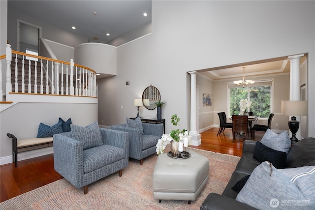 9702 S 230th Pl, Kent, WA 98031 - living area with ornate columns, a chandelier, wood finished floors, stairway, and crown molding
