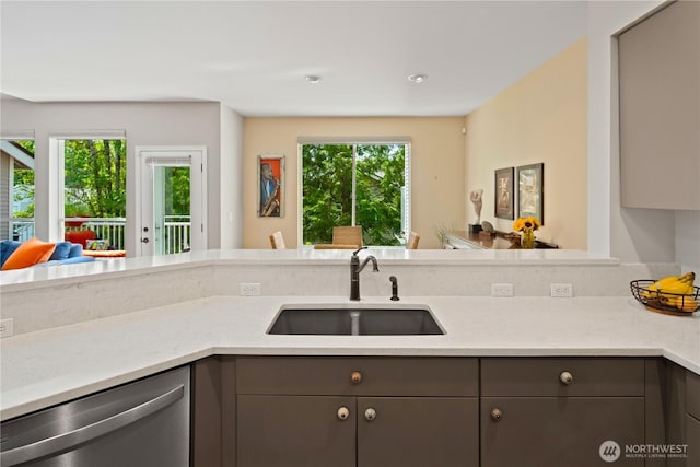 kitchen with dishwasher, a sink, gray cabinets, and plenty of natural light