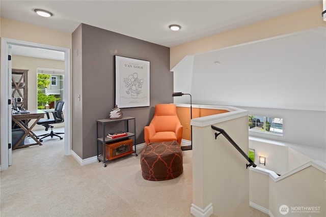 living area with a desk, an upstairs landing, carpet floors, and baseboards