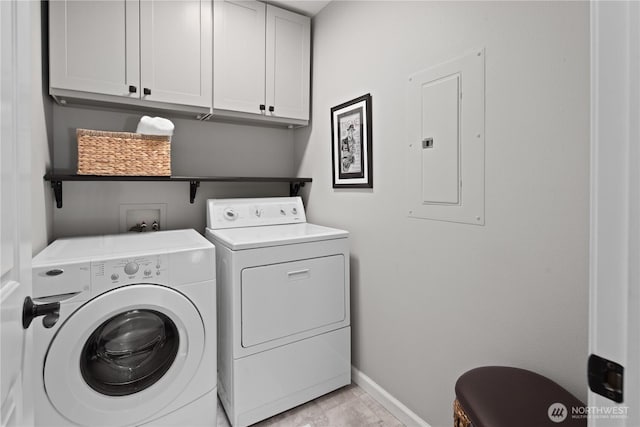 washroom featuring washer and clothes dryer, cabinet space, electric panel, and baseboards