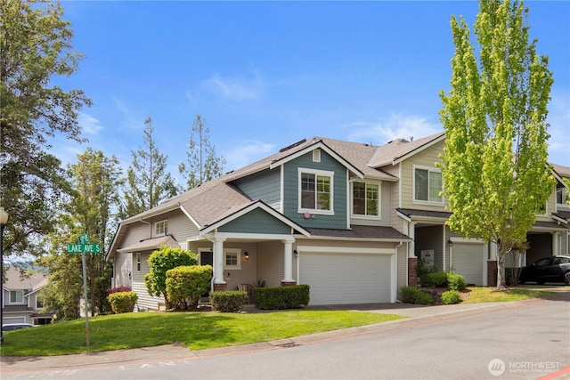 view of front of home featuring an attached garage, a front lawn, driveway, and a shingled roof