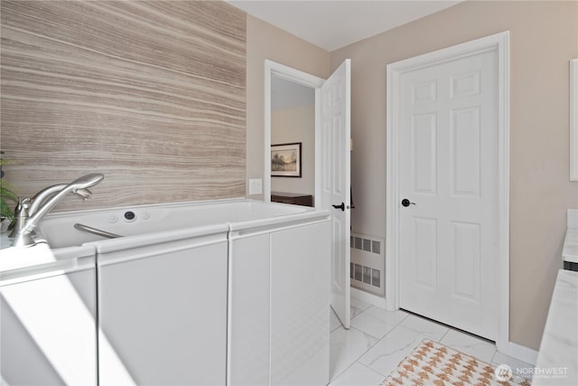 laundry room featuring washing machine and clothes dryer and light marble finish flooring